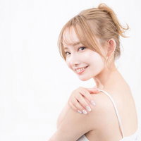 優しく微笑む美容女子の横顔と素肌の背中、艶やかな髪の写真