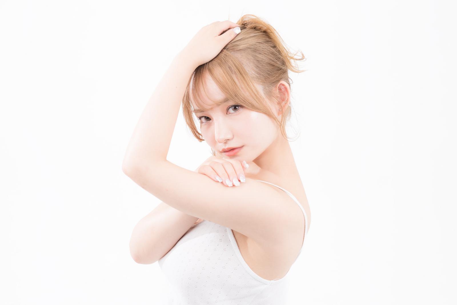 腕を上げてポーズする、脇を見せるキャミソール姿の女性［モデル：yuria］