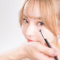 アイブロウブラシを使用したアイメイクの女性の写真