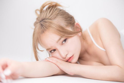 透明感際立つ素肌美人がテーブルにもたれてリラックスする様子