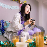 生誕祭パーティーでゲームコントローラーを握る女性の写真