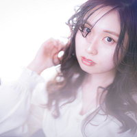 ゆるふわ巻き髪をした眼鏡をかけた若い女性のビューティーの写真