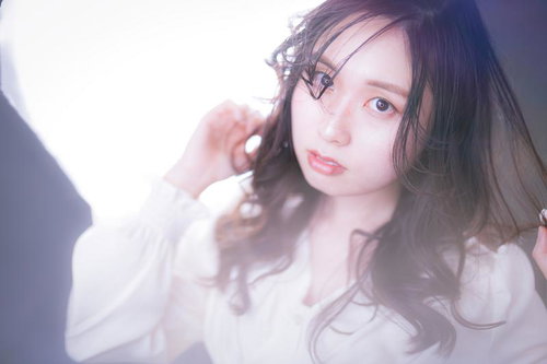 ゆるふわ巻き髪をした眼鏡をかけた若い女性のビューティー