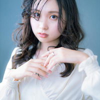 白いシャツにシルバーの指輪をつけた若い女性のガーリーなポートレートの写真