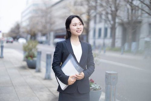 書類を抱えて外回りに向かうスーツ姿のOL