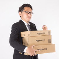 スーツ姿の男性がダンボール箱を抱えて怒るの写真