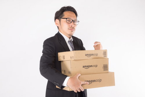 スーツ姿の男性がダンボール箱を抱えて怒る