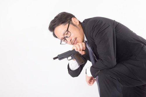 弾詰まりと時間を同時にチェックする殺し屋の男性