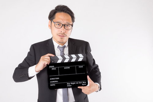 緊張感ある現場のカチンコ役を務めるスーツの男性（本番）