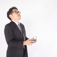 ドローンを操縦する男性会社役員がプロポで上空確認の写真