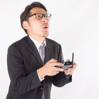 ドローンを自動帰還したのにジオフェンス外へ飛んでしまった時の会社員男性の表情の写真