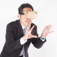 仮想空間で何かを揉むビジネスマン、VRゴーグル装着の男性の写真