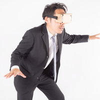 バーチャルリアリティーの中で落下しそうな会社員男性の写真