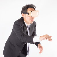 VRゴーグルを装着してスイッチを押す男性の写真