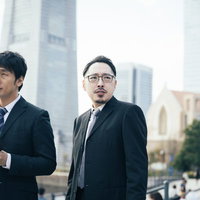 観光地で聞き込み捜査をする刑事と記者の取材風景の写真