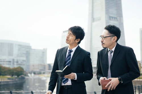 難しい捜査に苦戦を強いられるスーツ姿の二人の男性