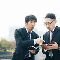 捜査メモの誤字脱字を指摘するスーツ姿の男性記者の写真