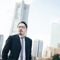 俺がこの街のランドマークだ、みなとみらいに立つスーツ姿の男性の写真