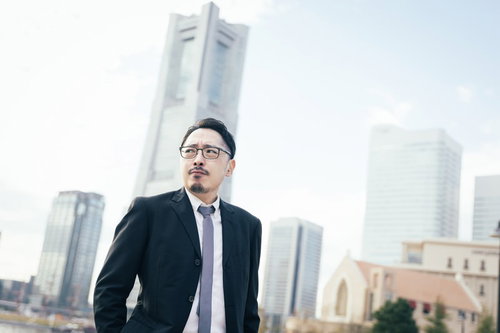 俺がこの街のランドマークだ、みなとみらいに立つスーツ姿の男性