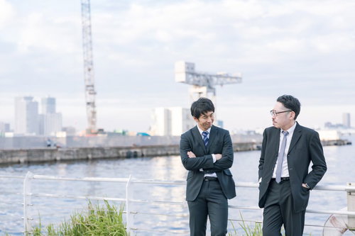 捜査中に談笑する刑事と記者の港での会話風景