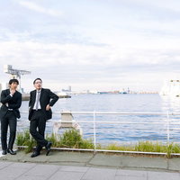 港で張り込みをするスーツ姿の刑事と記者たちの監視風景の写真