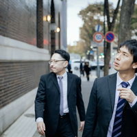 先輩、ここを右です おう スーツ姿の記者が聞き込み調査の写真