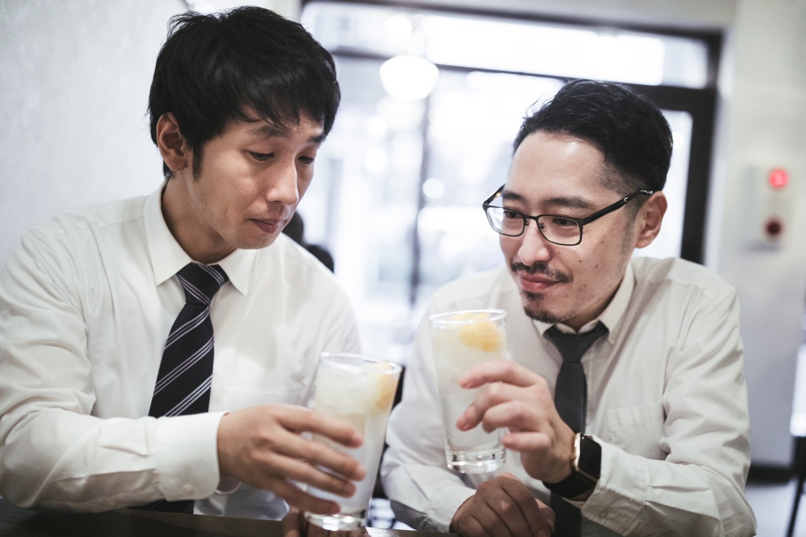 スーツの2人の男性がグラスを持って向かい合っている［モデル：大川竜弥 ゆうせい］