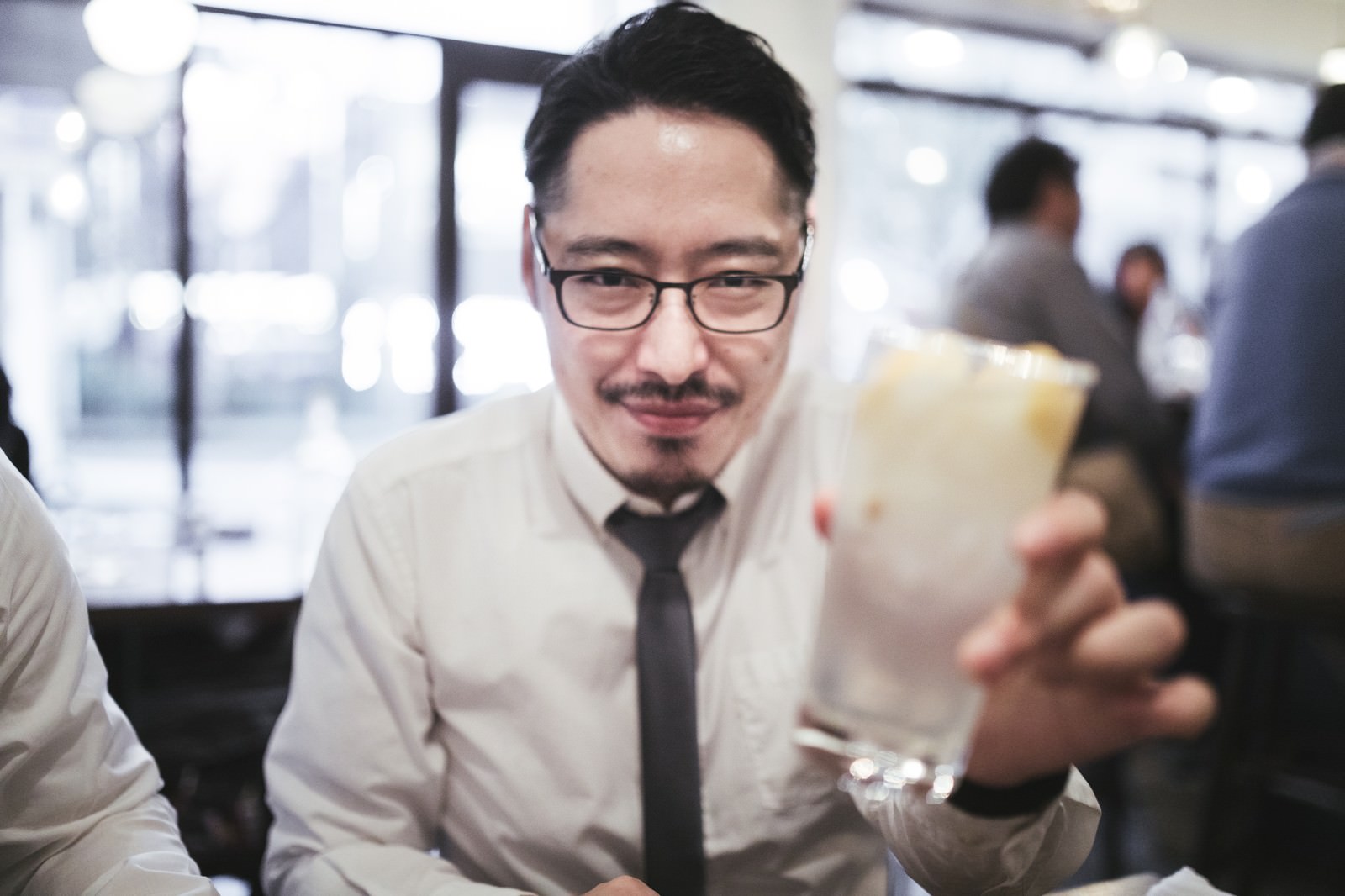 休肝日でお酒を控えるスーツ姿の男性がレモンサワーを前にして困った表情をしている［モデル：ゆうせい］