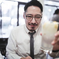 接待の宴会で乾杯をする浮かない顔の男性会社員の写真