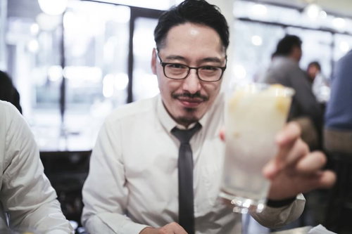 接待の宴会で乾杯をする浮かない顔の男性会社員