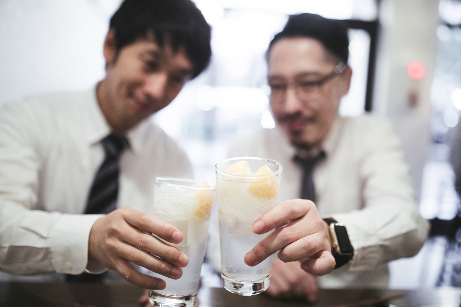 レモンサワーで乾杯するスーツ姿の男性［モデル：大川竜弥 ゆうせい］
