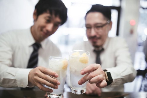 レモンサワーで乾杯するスーツ姿の男性