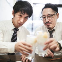 プライベートも仲良しなスーツ姿の上司と部下の乾杯の写真