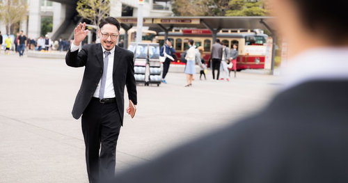 「お待たせ」と手を挙げる男性