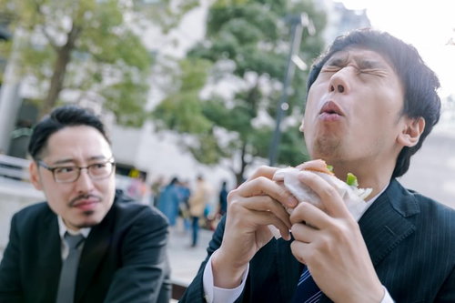 カメラが回っている時だけオーバーリアクション気味にグルメレビューするスーツ姿の男性