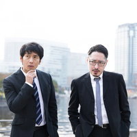 捜査に行き詰まるスーツ姿の刑事と記者の張り込み現場の写真
