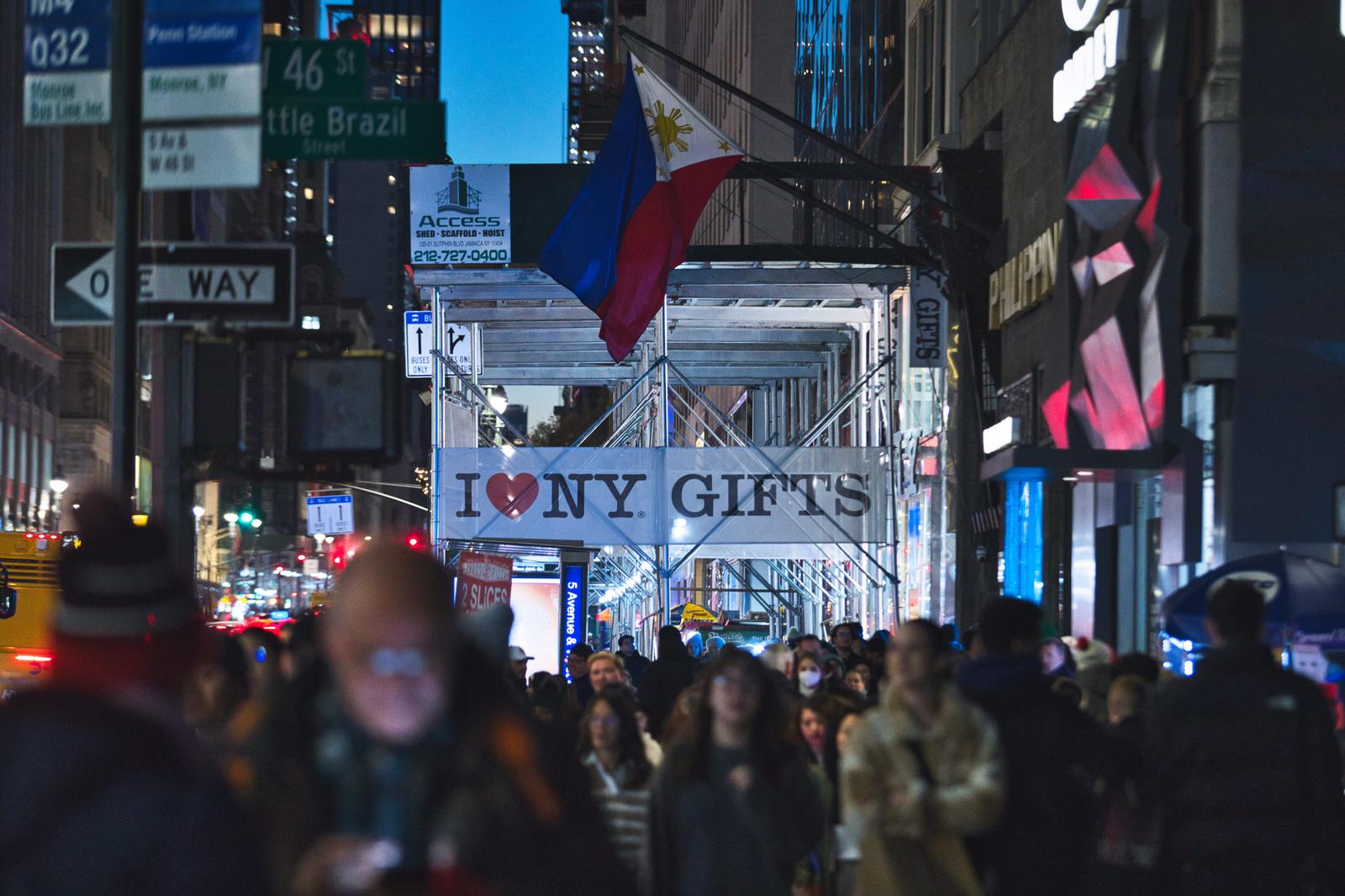 ニューヨークの繁華街でI LOVE NY GIFTSの看板が見える人混みの夜景