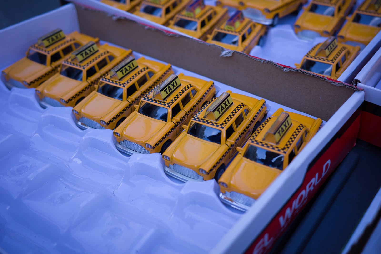 白いケースに並んだイエローキャブのミニカー