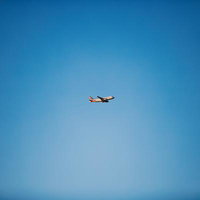 アメリカンエアラインの旅客機が青空を飛ぶの写真