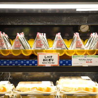 コンビニのショーケースに並ぶ鮭おにぎり・おむすびの写真