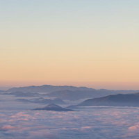雲海に浮かぶ山々の朝焼けの写真