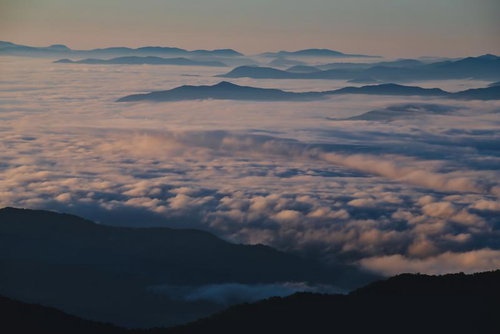 山々を超える一面の雲海と朝焼け、高山から眺める層状雲と早朝の絶景