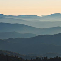 朝霧に包まれた美しく重なる稜線と山々のパノラマ風景の写真