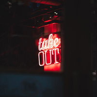 赤く光るネオン管のテイクアウト看板、BAR・飲食店の夜間営業の写真