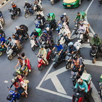 交差点に集まるバイクとスクーターの群れの写真