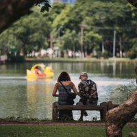 湖畔のベンチに座るカップルの写真