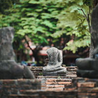 ワット・マハータートの首のない石造仏像と赤煉瓦の遺跡の写真