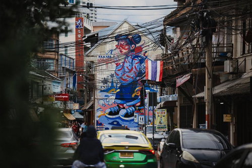 壁一面に大きなストリートアートが描かれた狭い路地