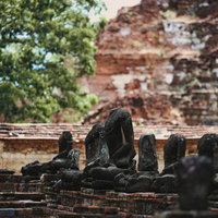 頭部を失った石仏が並ぶ古代遺跡の台座群の写真