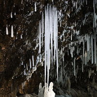 岩壁から垂れ下がる氷柱の造形の写真